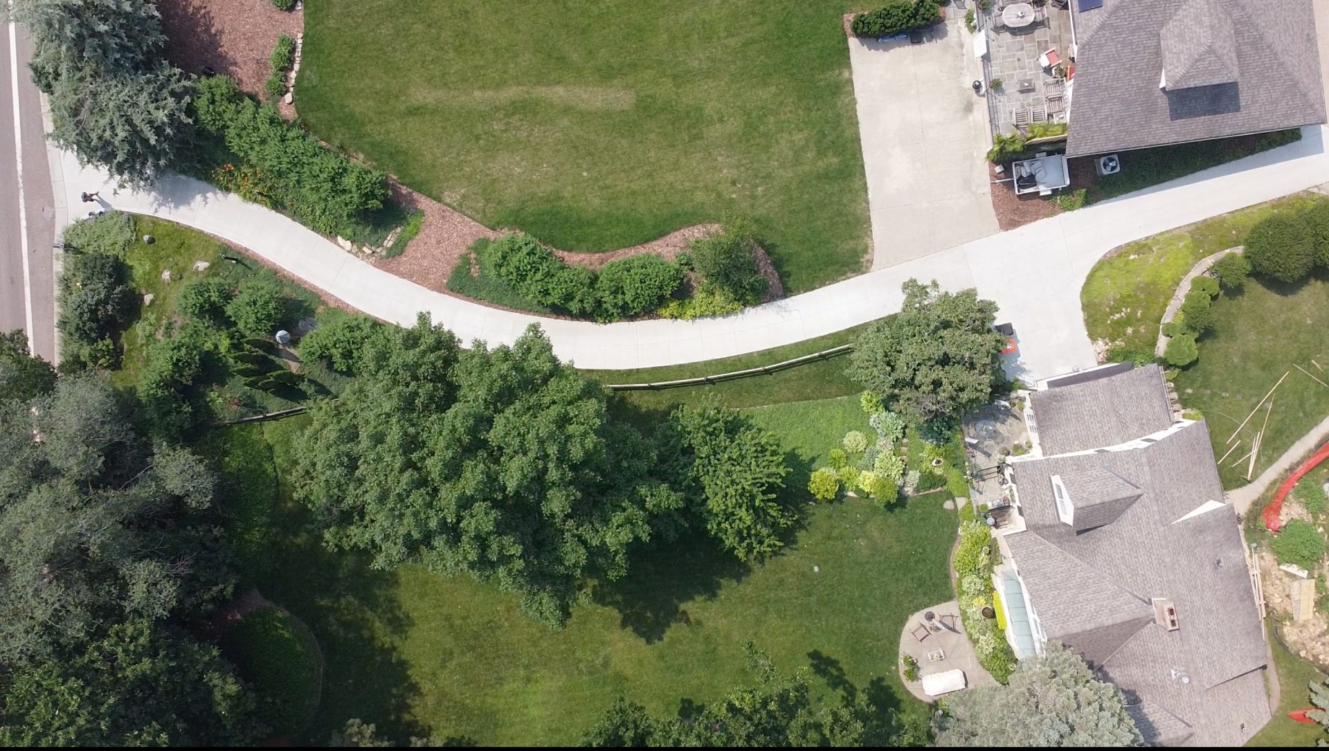 Aerial view of a curved concrete driveway connecting two properties in Hopkins, MN