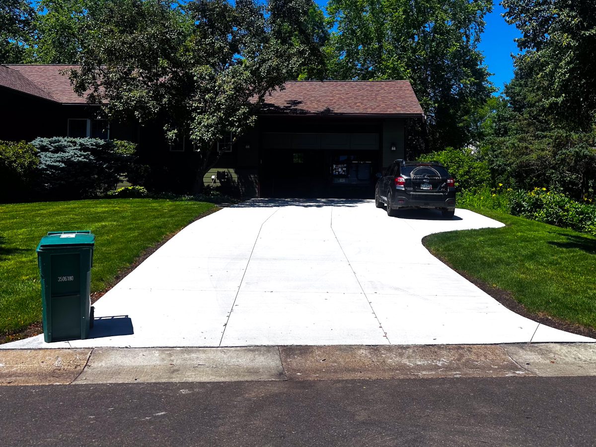 Newly poured concrete driveway leading to a two-car garage on a Brooklyn Center, MN home